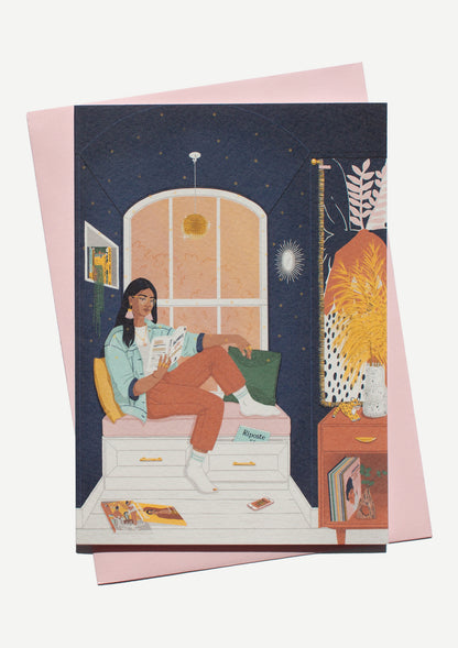 Illustration of a South Asian woman reading in a nook. She is sat by the window in a nook and she is surrounded by books, magazines, and vinyls.