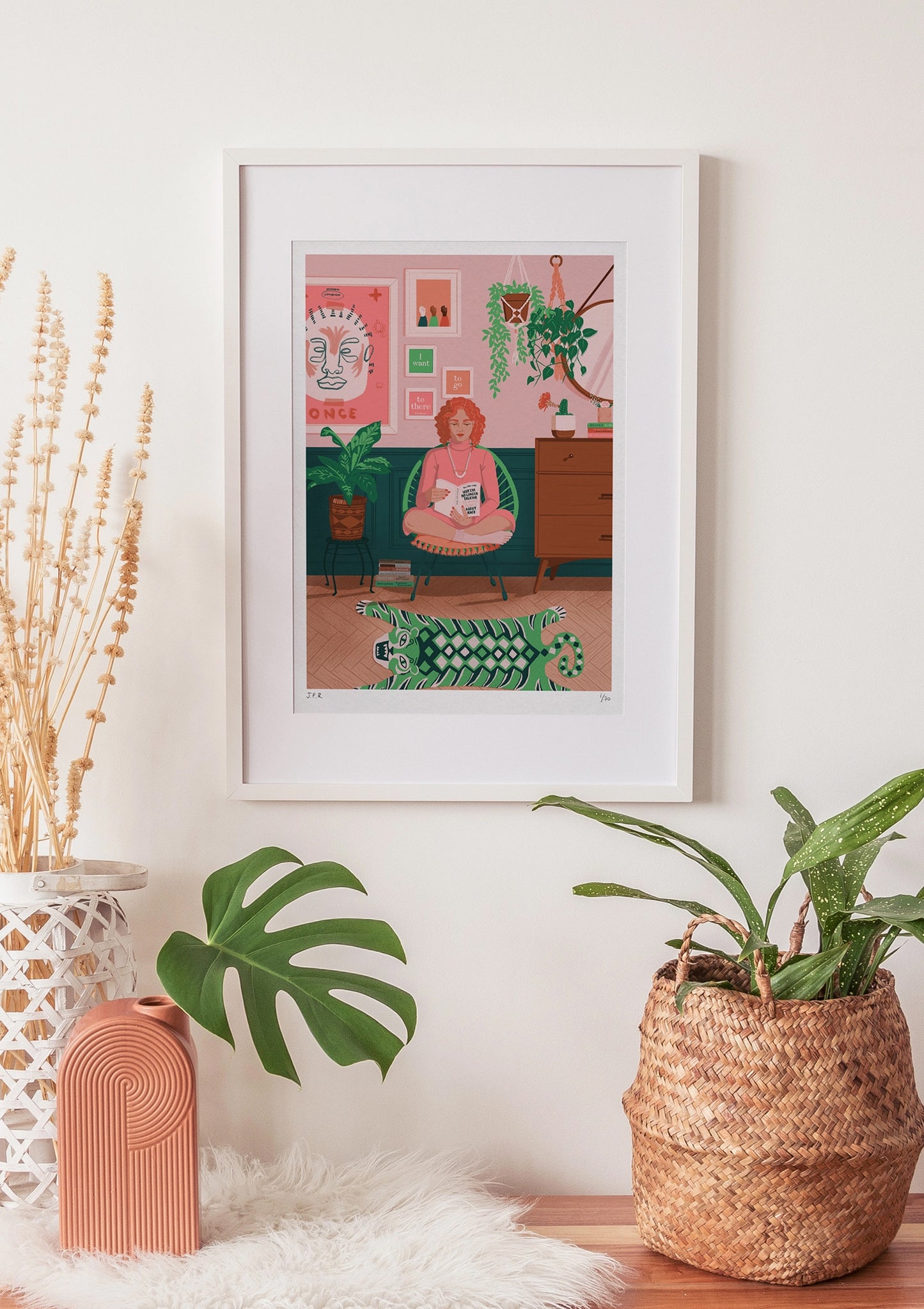 Framed illustration of a White woman reading the book Why I'm No Longer Talking To White People About Race by Reni Eddo-Lodge. She is sat in her pink and green living room, surrounded by plants and books