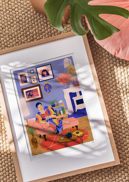 Framed illustration of an East Asian woman reading the book Don't Touch My Hair by Emma Dabiri. She is sat on a chaise long in her living room, surrounded by lovely objects, books and picture frames on the wall. She is wearing a multi-coloured dress.